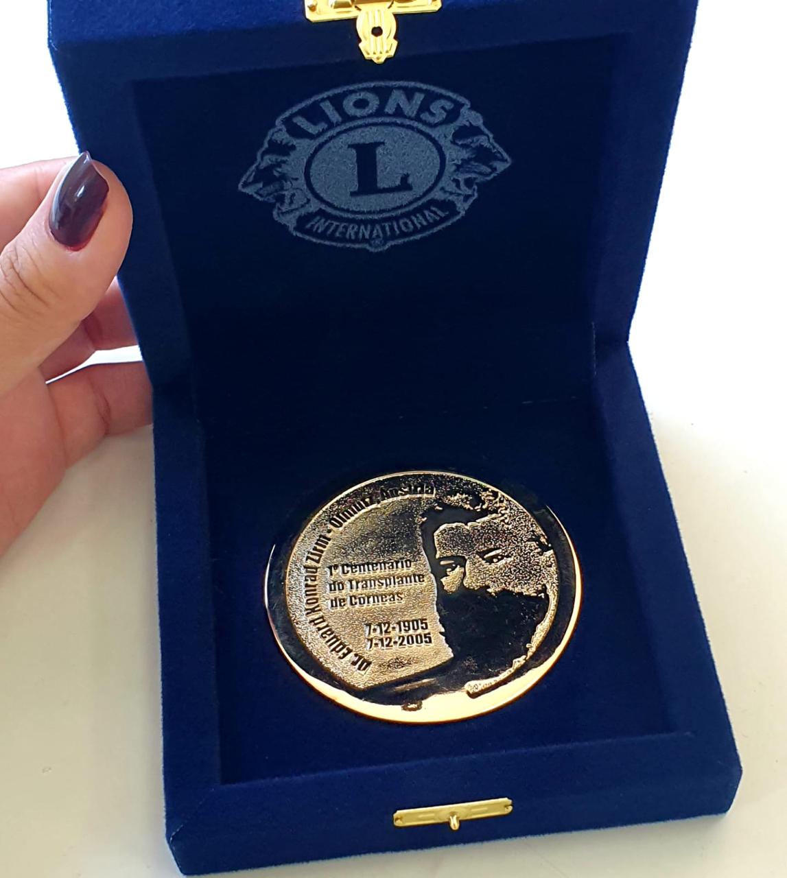 Estojo azul em veludo com logo gravado e medalha comemorativa