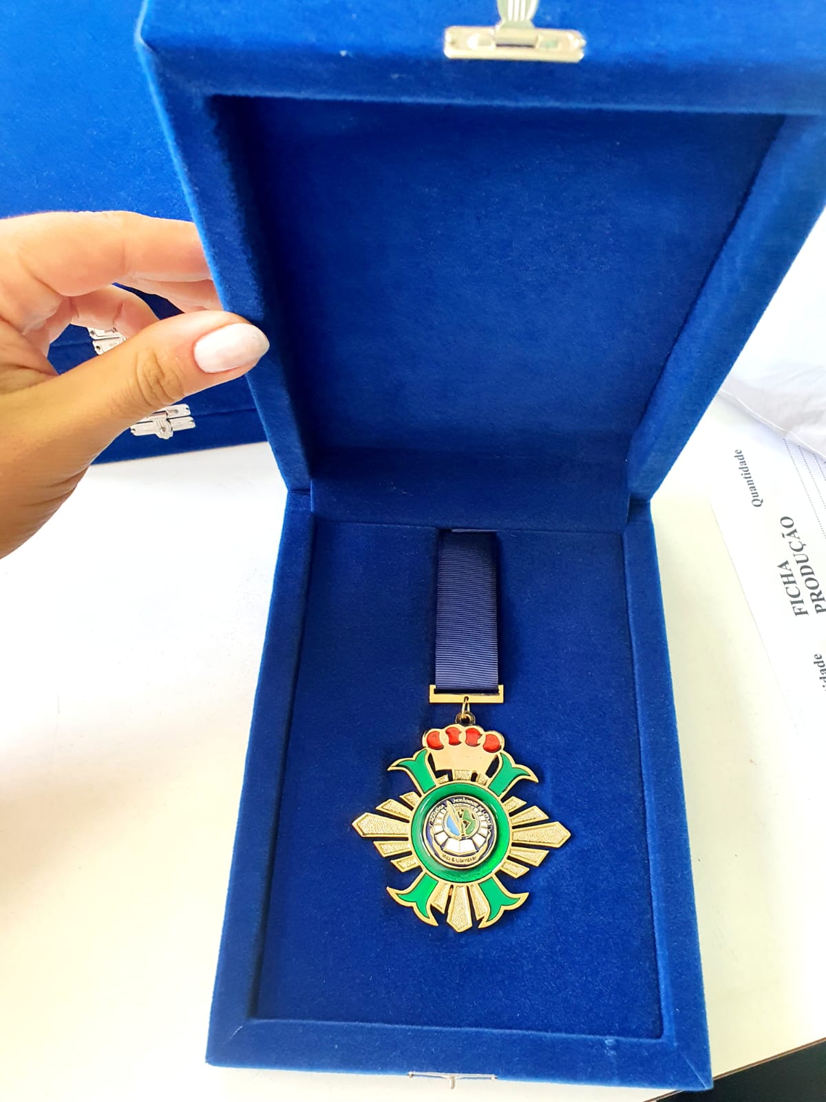 Estojo azul royal em veludo com medalha comemorativa dourada