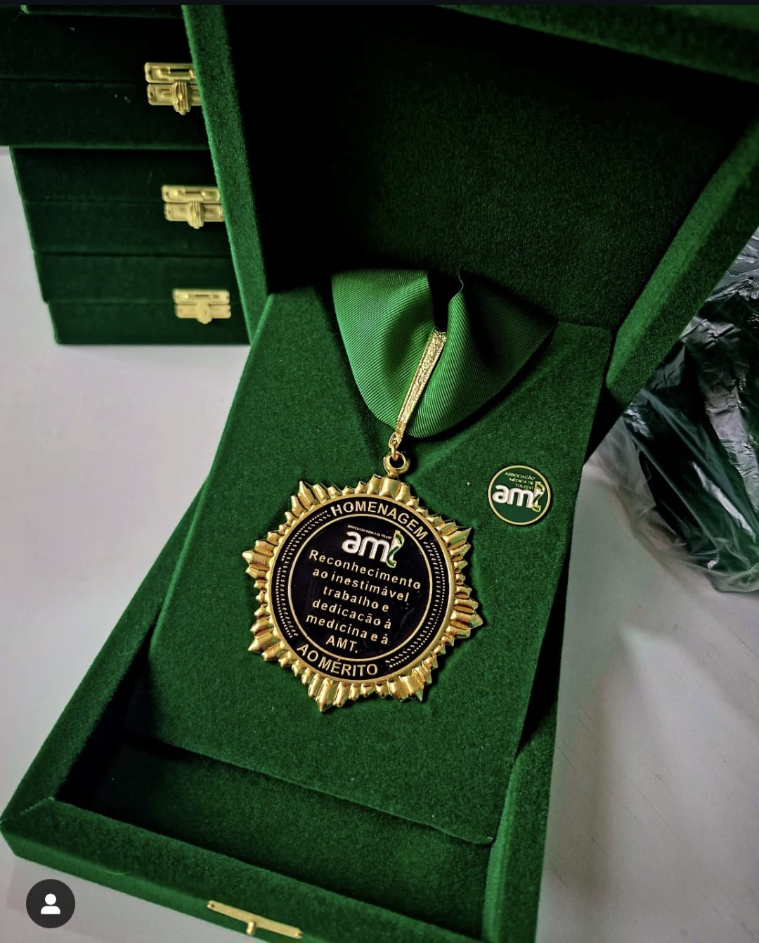 Estojo verde em veludo com medalha de homenagem ao mérito